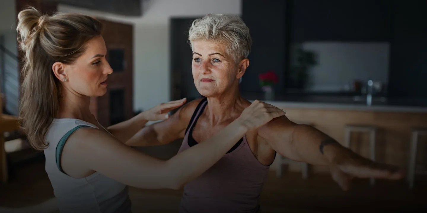 Functional aging specialist helping client stretch.