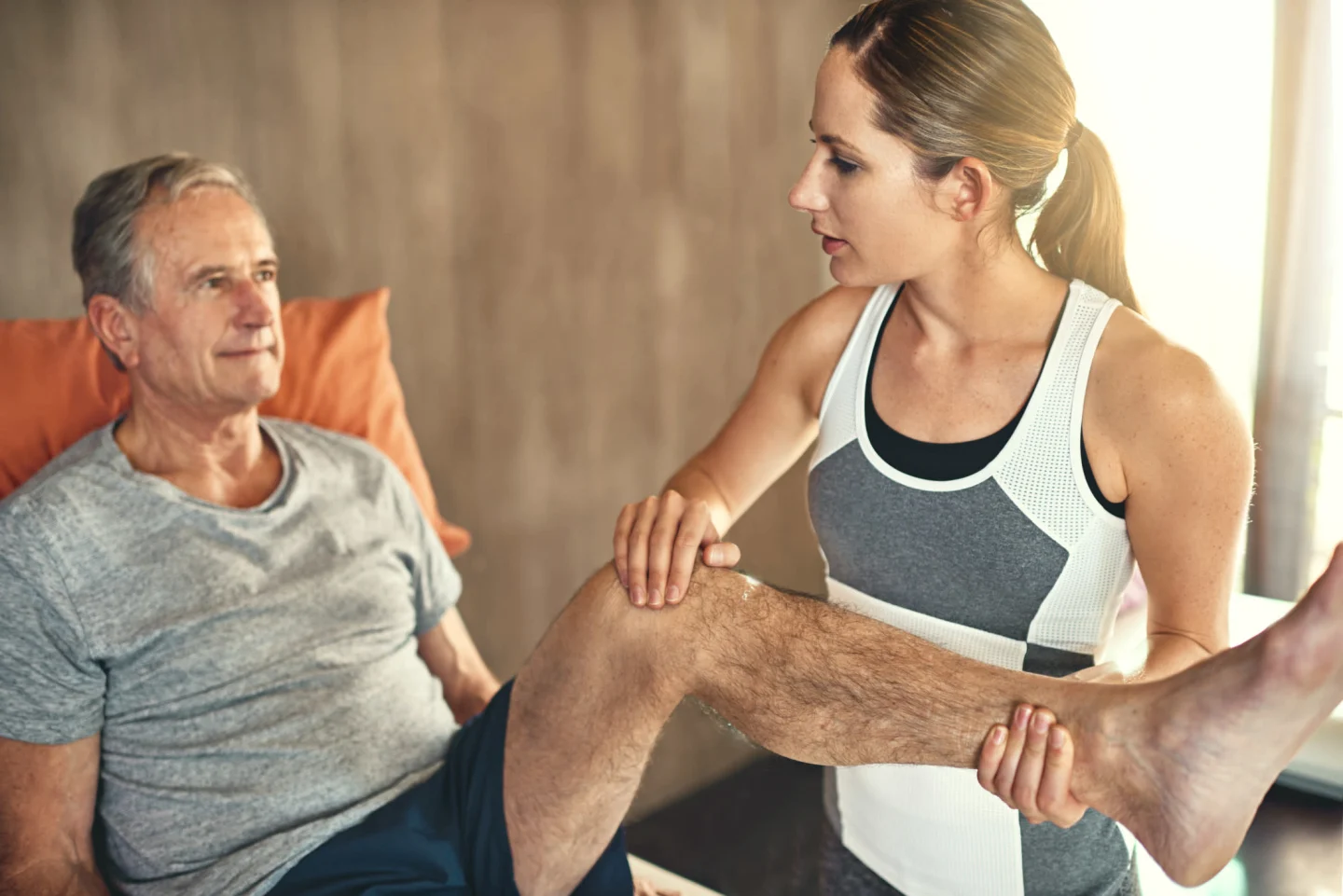 Mature client with fitness trainer working on fitness with joint replacement