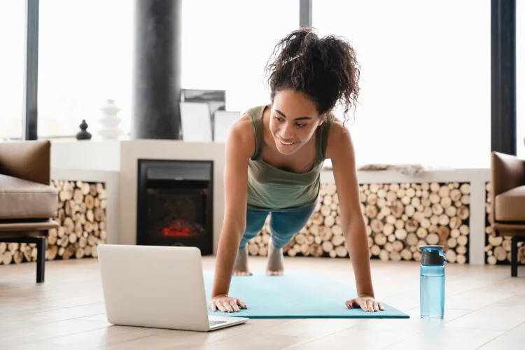 ISSA trainer on a mat looking at a laptop