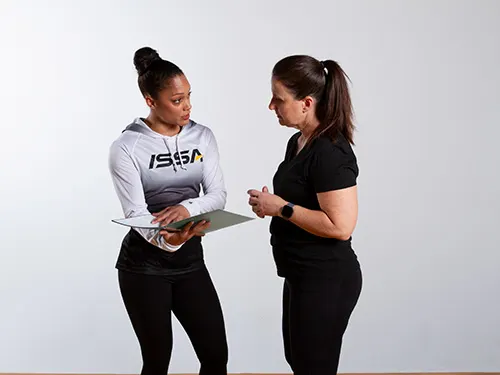 ISSA Certified Personal Trainer speaking with a client