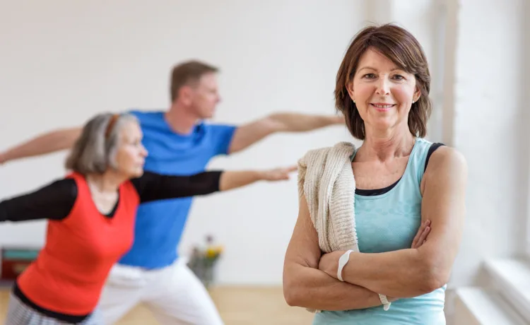 Man smiling alongside another trainer at a gym