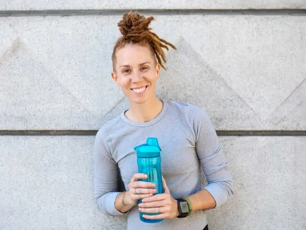 ISSA Trainer smiling and holding a water bottle