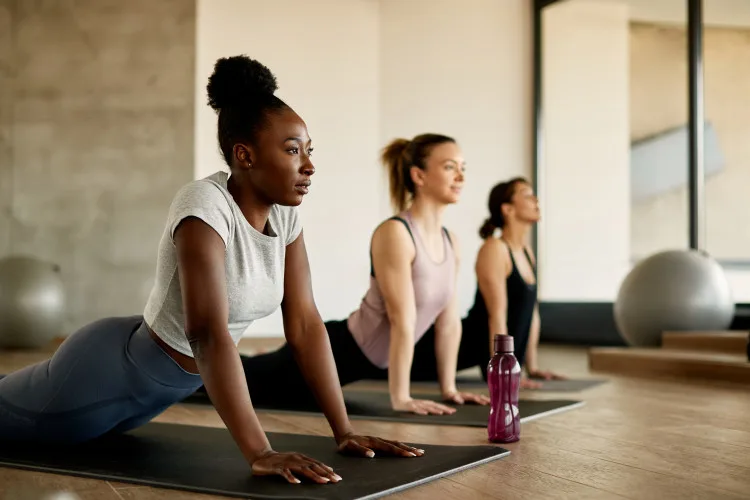 Black female athlete doing stretching exercises while warming up