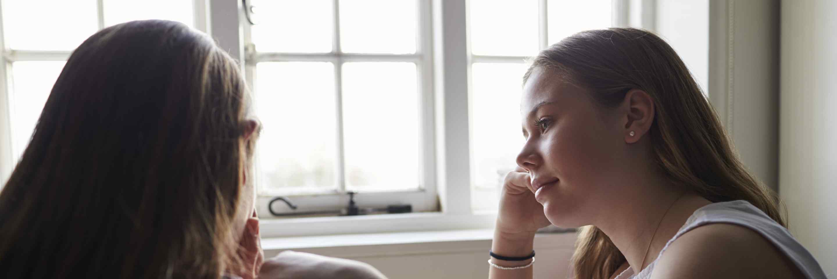 Girl comforting a friend indoors