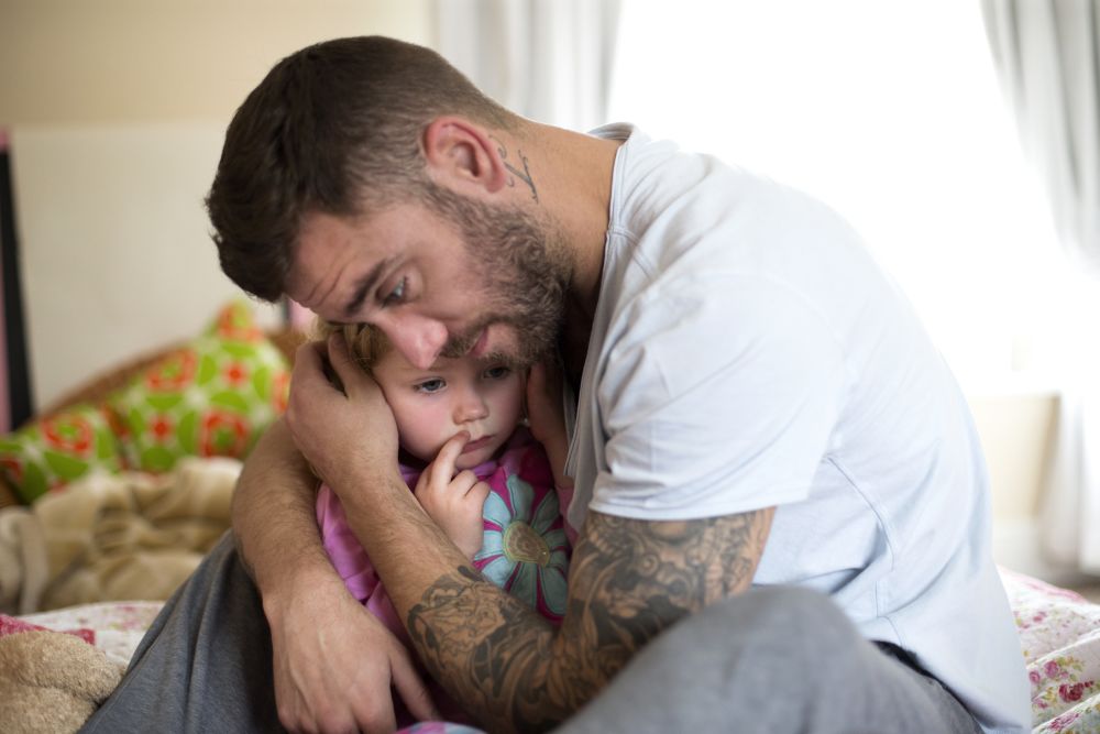 father cuddling child 