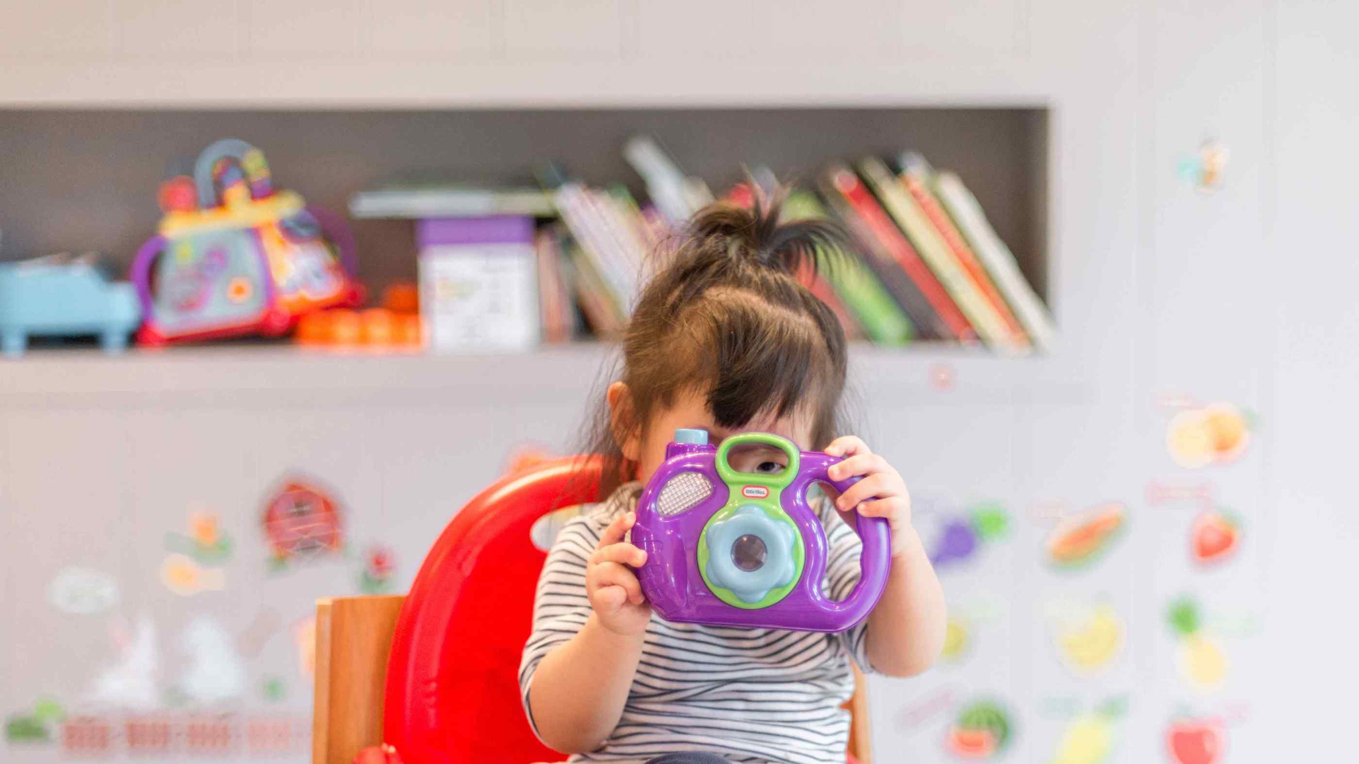 Toddler looking through toy camera