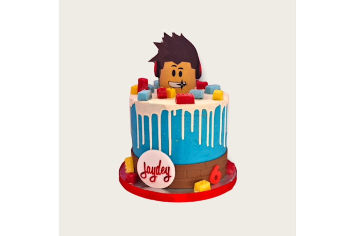 Prachtige drip taart in de kleur blauw en met eetbare blokjes. Blauwe Roblox taart