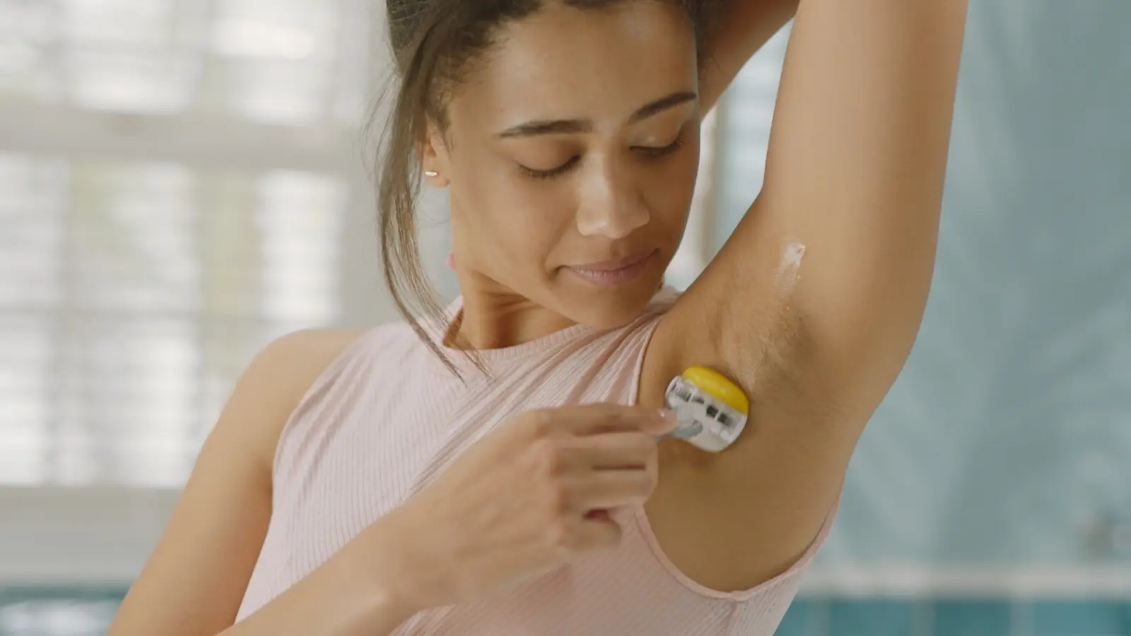 Woman shaving her armpit.