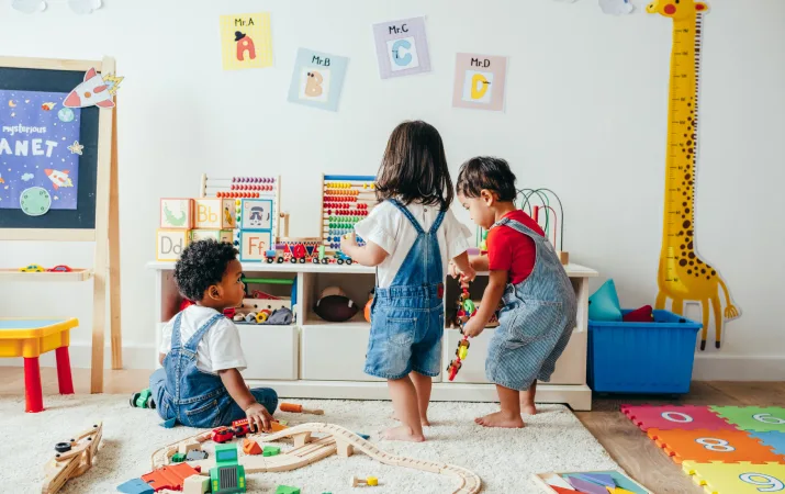 Three toddlers playing with toys in an early learning centre
