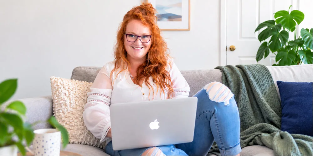 Postgraduate student Kimberley smiling and studying online in her home