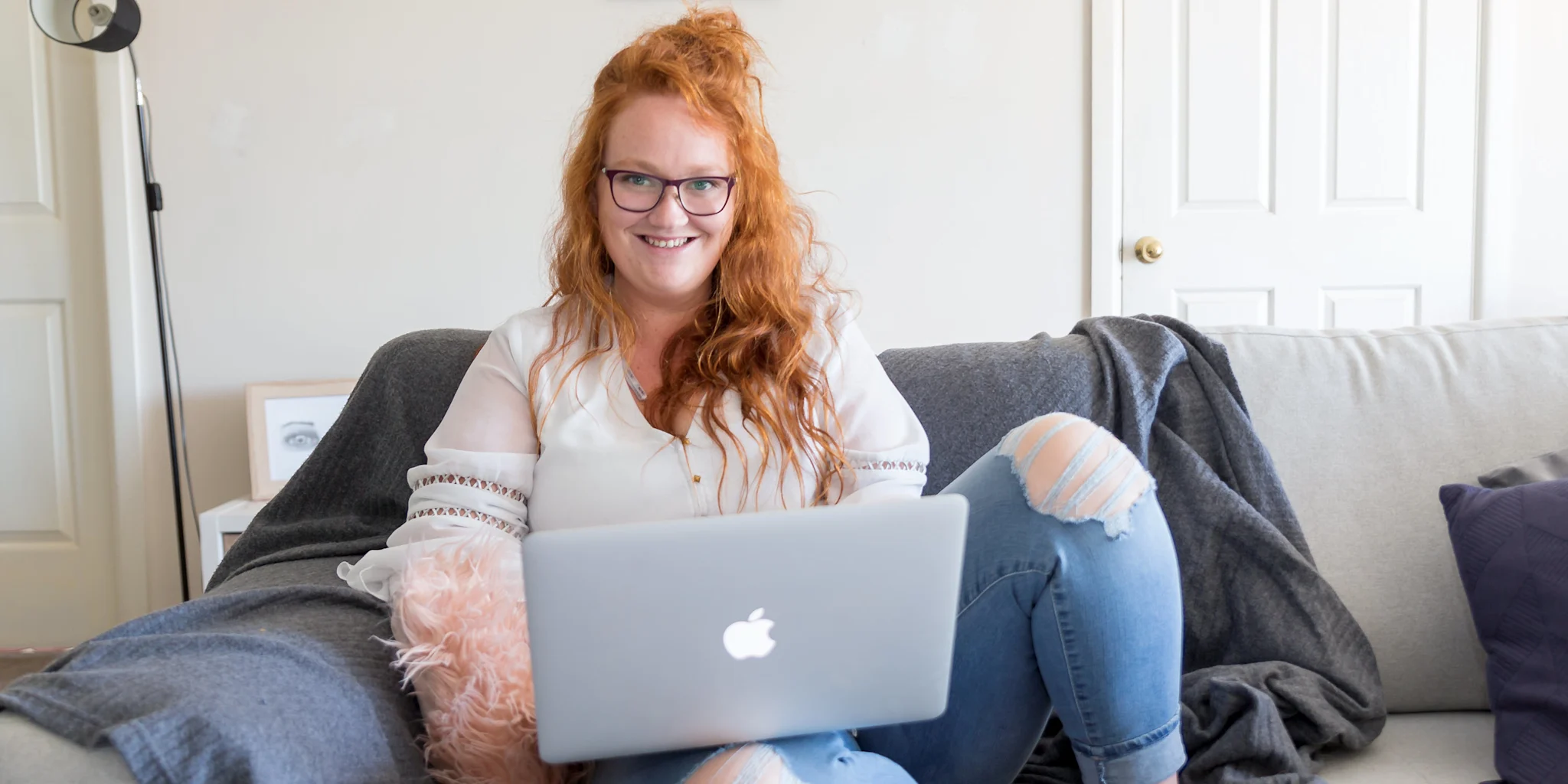Postgraduate student happily studying a single subject from home on her laptop in her lounge room.