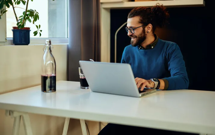 An aspiring teacher completing his teacher registration documents online on his laptop