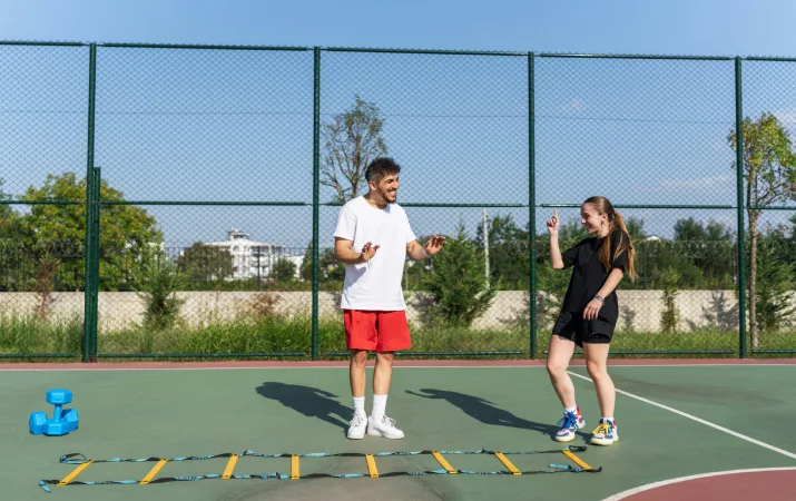 A provisionally registered teacher and a student in a physical education lesson outdoors