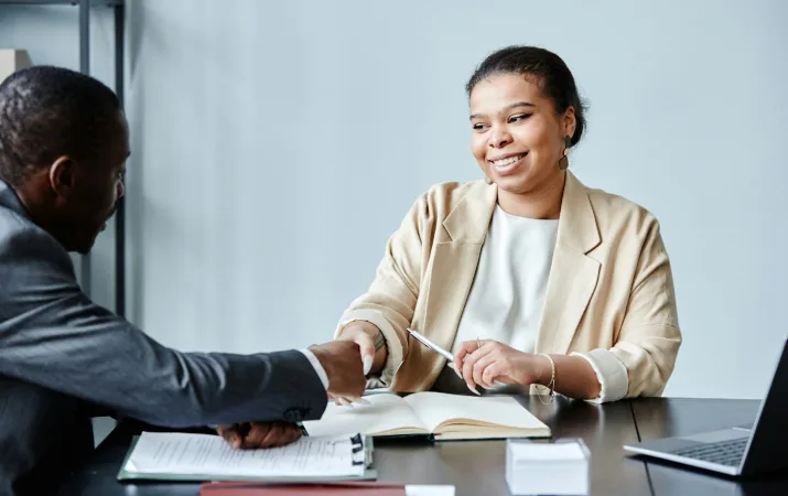 A law graduate shaking a colleague's hand during a meeting