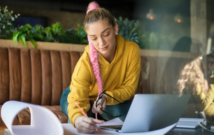 Woman with a pink braid on laptop