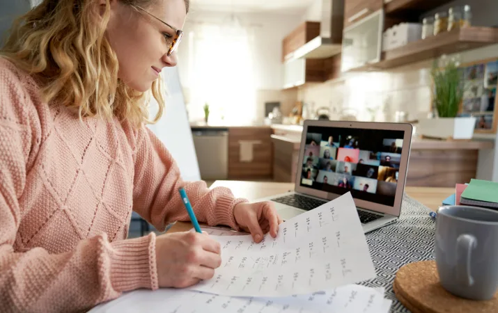 An online student reviewing her psychology coursework while viewing a live tutorial on her laptop