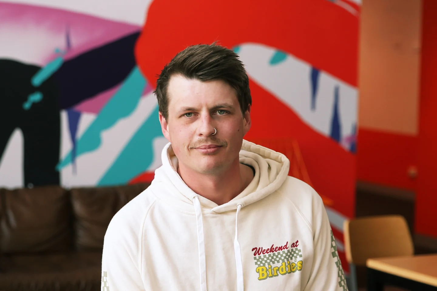 Calm student advisor in front of bright office mural