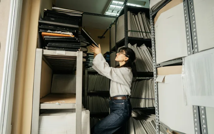 Woman retrieving folders in filing room