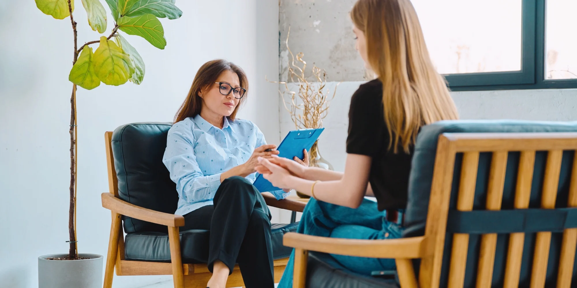 A mental health professional working with a patient in a calm and modern consulting room.