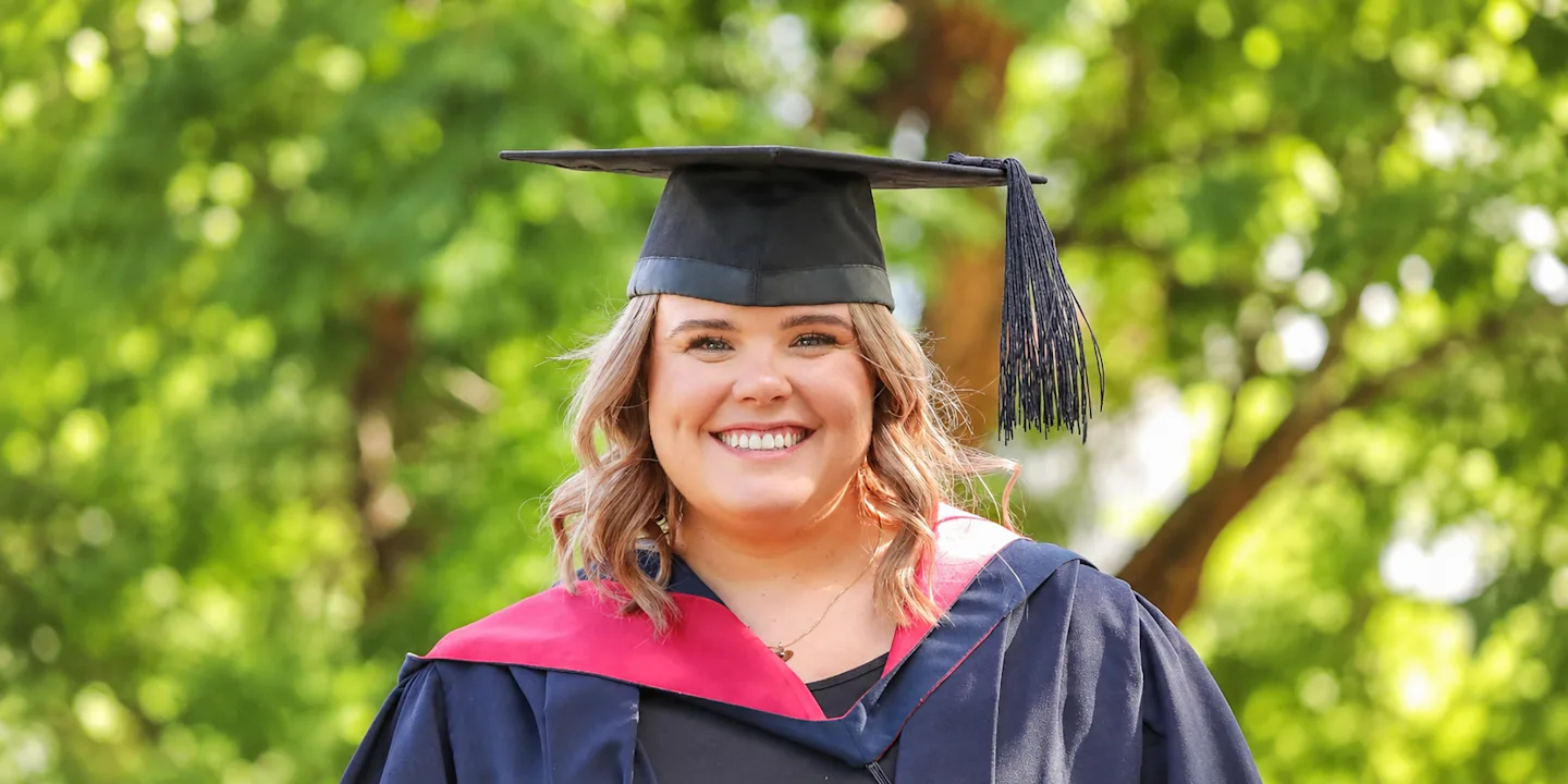 Portrait of La Trobe graduate Claire Littore in her graduation cap and gown.
