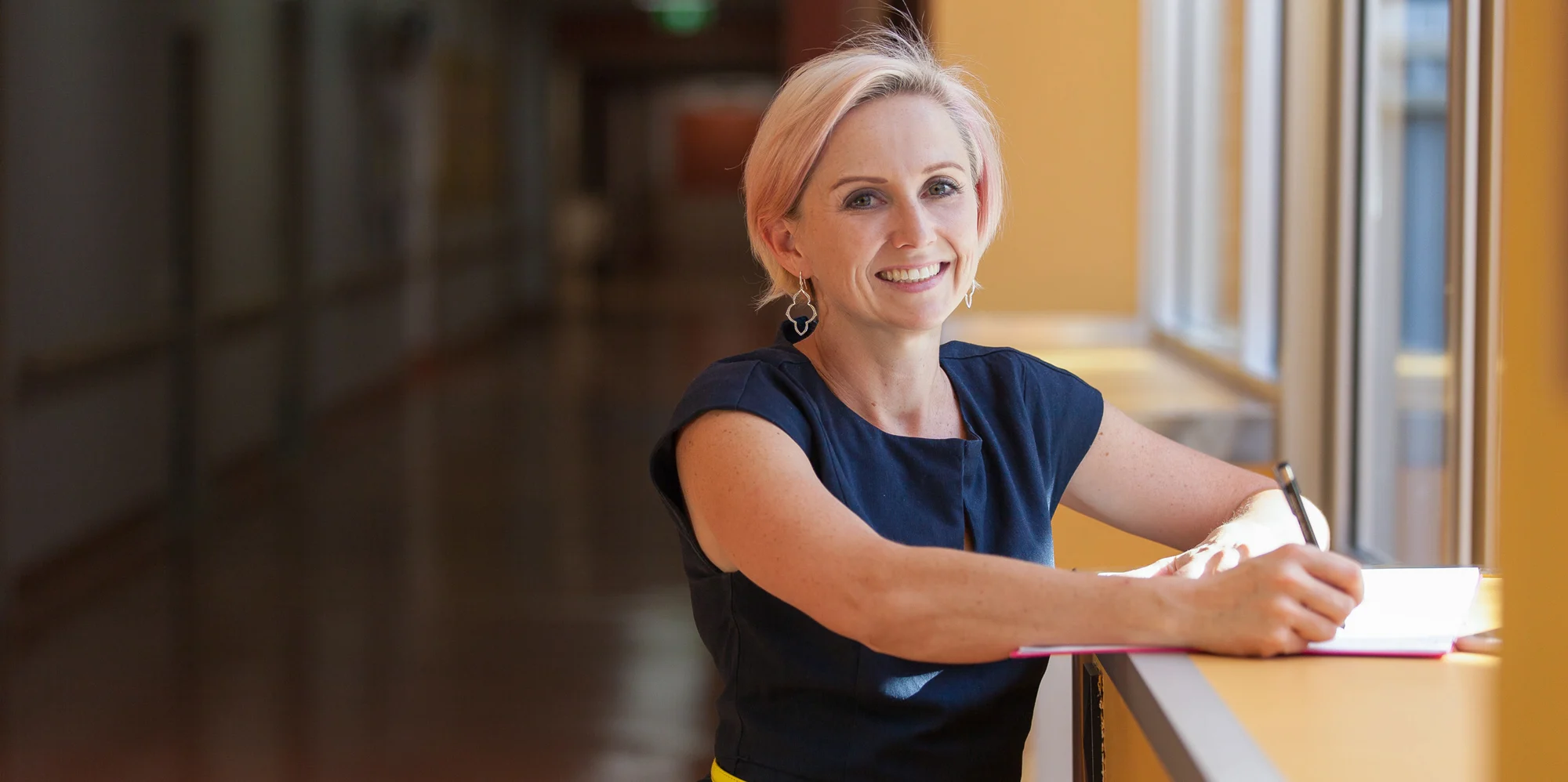 OUA student Brenda smiling at work in a large hospital.