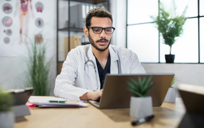A healthcare professional in his lab coat reading about making a career change into psychology