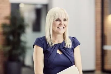 Open Universities Australia student Lisa wearing professional clothes in a business setting.