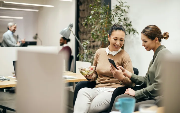 Two teachers bonding at their desks while eating lunch