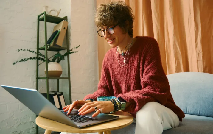A woman with short hair working from home on a laptop