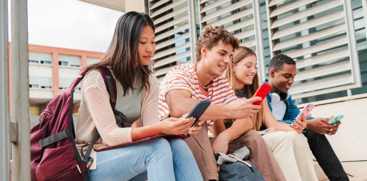 Four students checking their school results on their phones