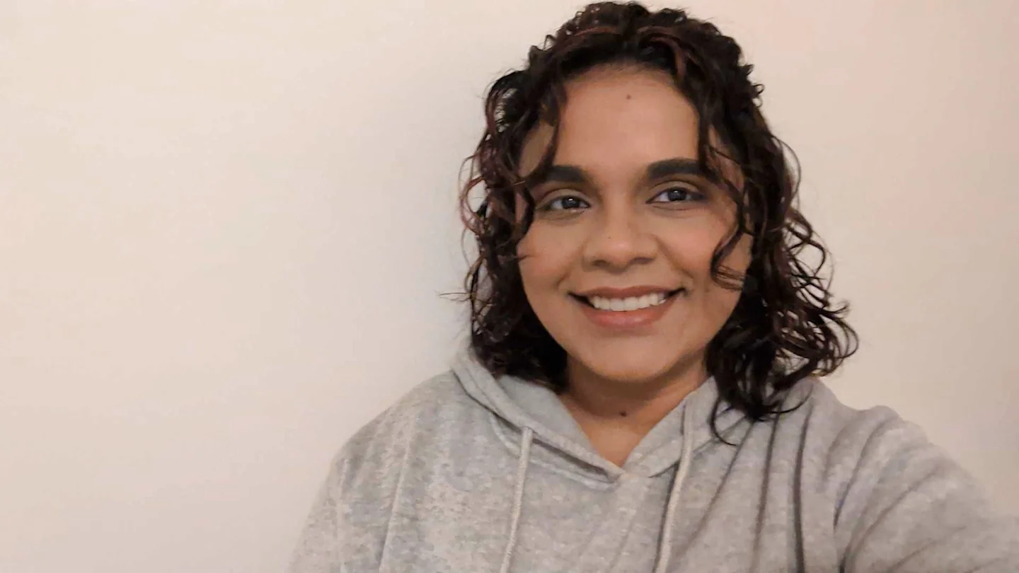 A happy short-haired woman smiling in grey hoodie