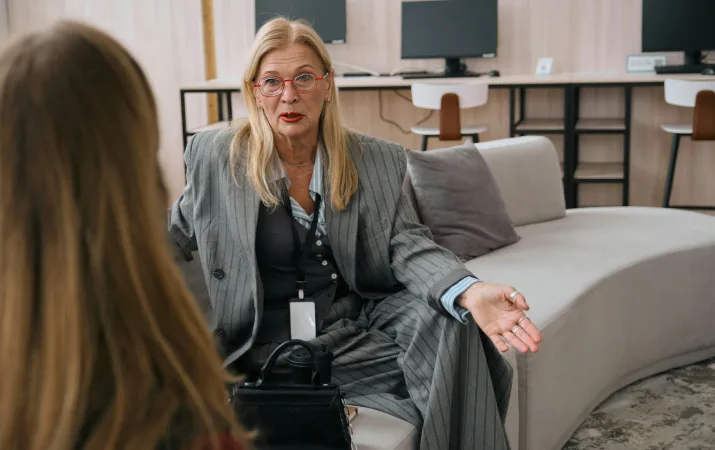 Older woman speaking with client in casual office