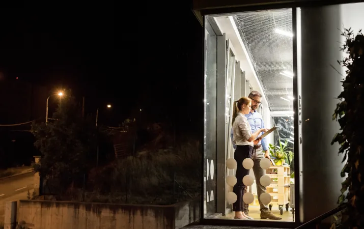 Two teachers working late as it gets dark outside their school