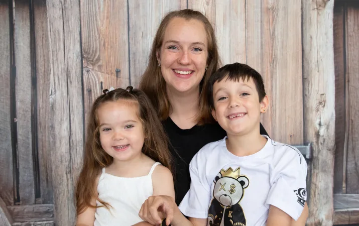 Annika posing with two happy children at her centre