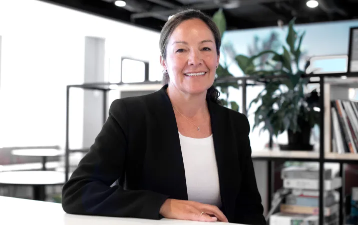 An expert on teacher wellbeing smiling confidently at her desk at Beyond Blue
