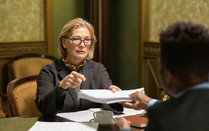 senior lawyer handing contract to client