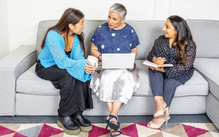 An older woman advising two younger diverse women