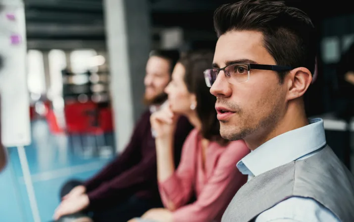 Three people sitting in a waiting area.