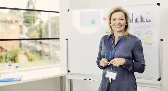 Open Universities Australia student, Louise, standing in front of a whiteboard.