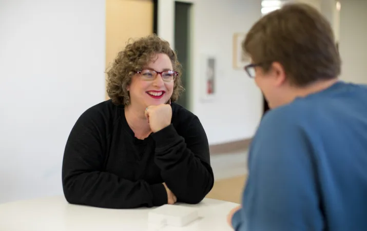 Woman with glasses smiles at medical receptionist