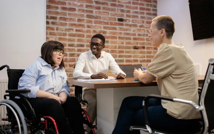 Two outcome evaluators chatting with a woman in a wheelchair