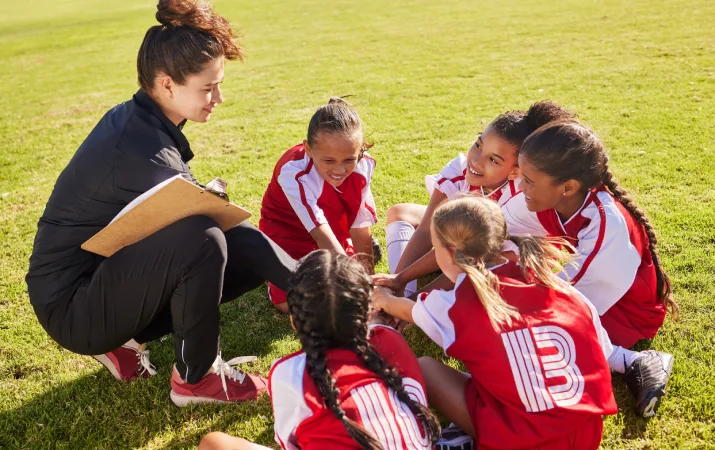 A woman volunteering as a girl's soccer team coach