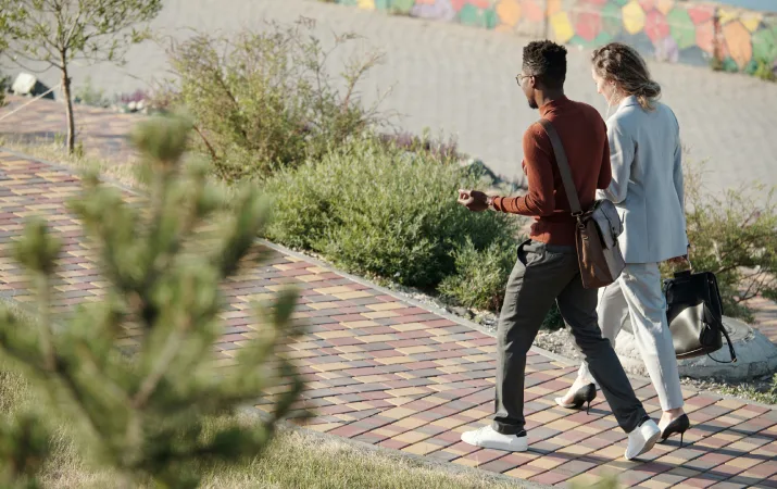 Two criminology graduates chatting and walking along a path 