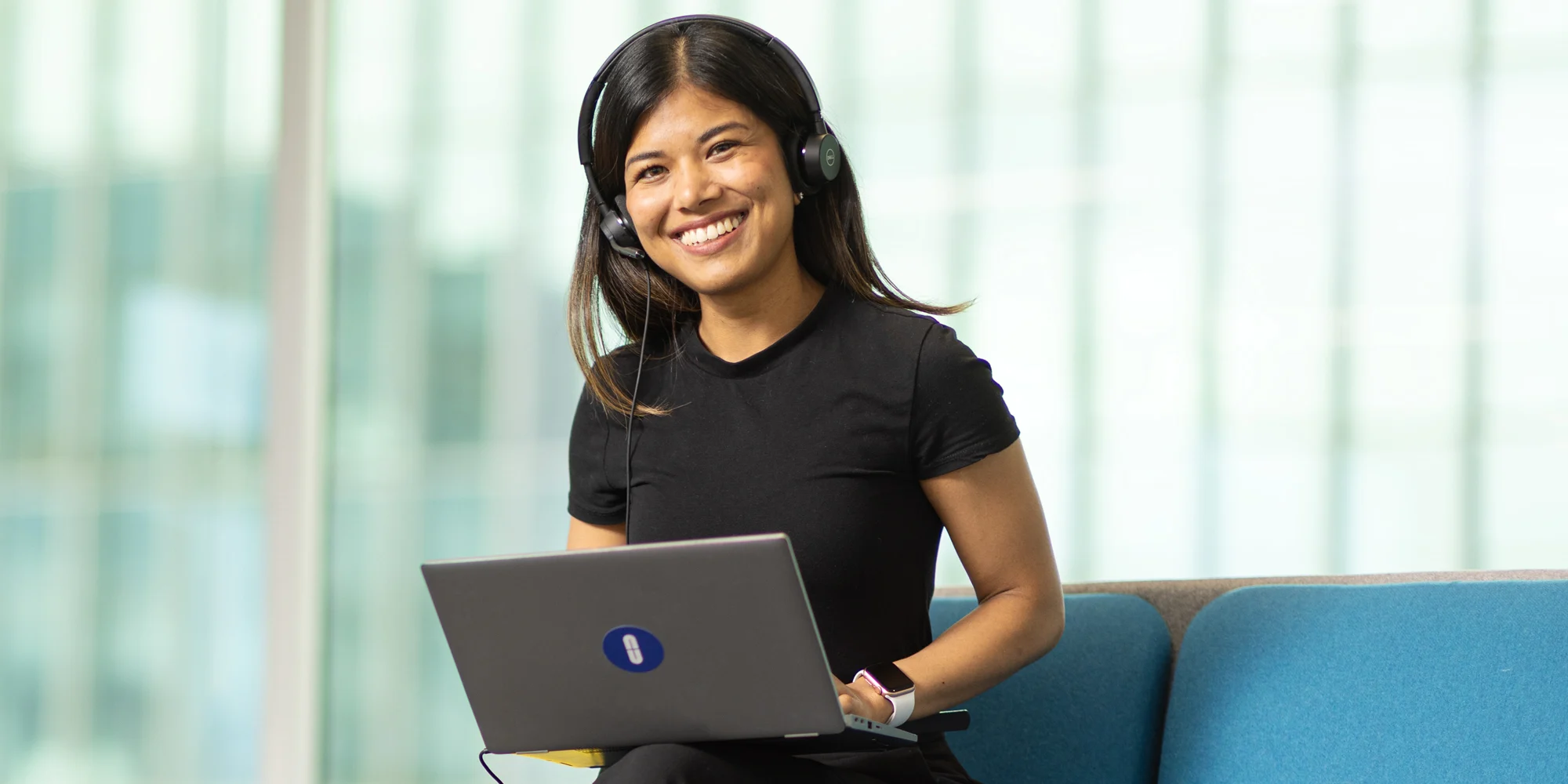Natcha, a smiling student advisor wearing a headset at her workstation, ready to help with student questions.