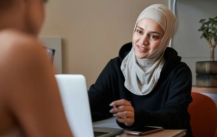 A young Muslim teacher who works full time meeting with one of her students in her office