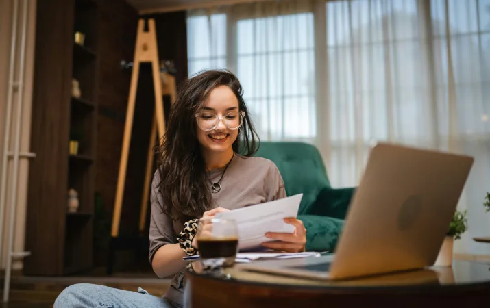 A student happily reading her equity scholarship acceptance letter in her home