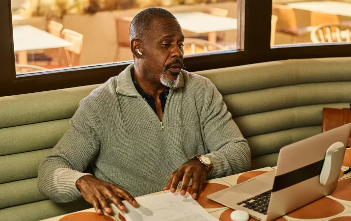 An older man intently studying law at a cafe desk