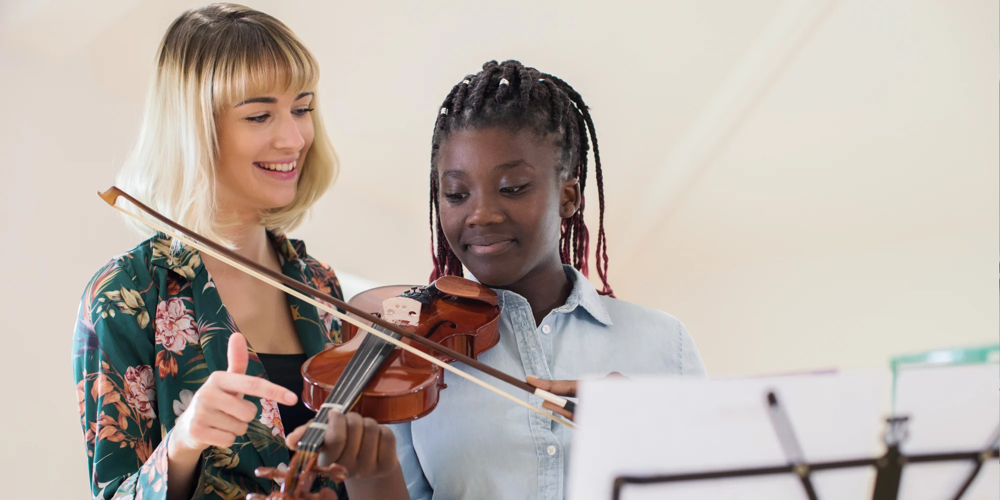 A secondary school music teacher inspiring a student during a violin lesson