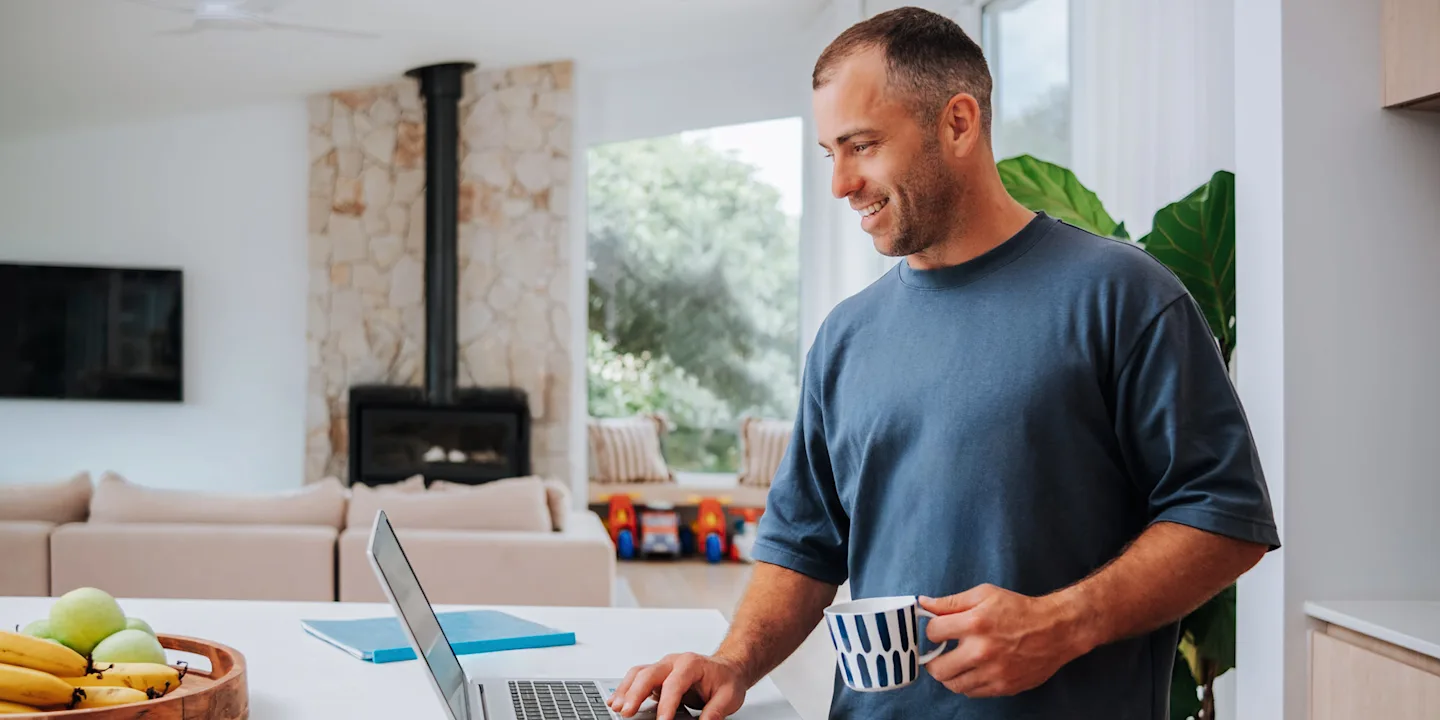 Smiling student using a laptop at home