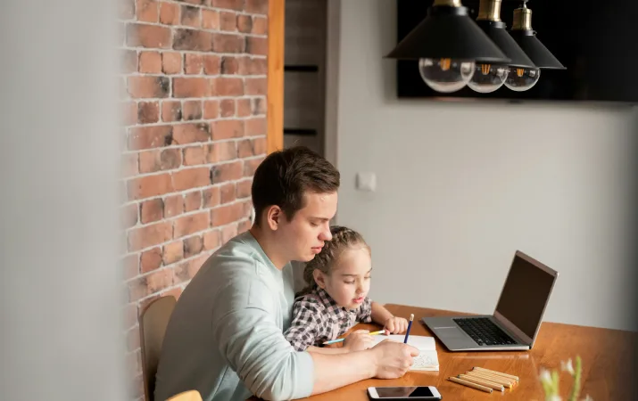 A father studying with his young daughter